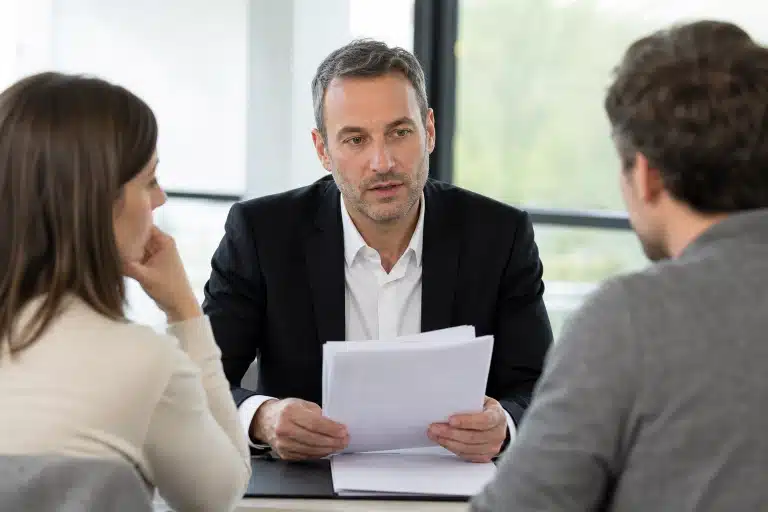 Homme en costume tenant des documents lors d'une réunion